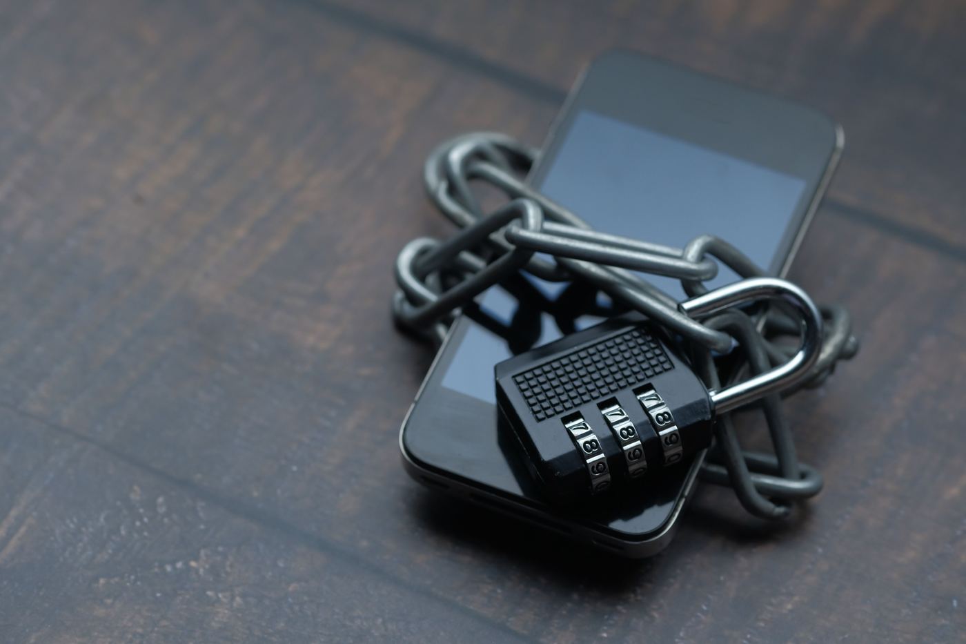 Smartphone protegido por cadeado e corrente, representando segurança e proteção de dados.